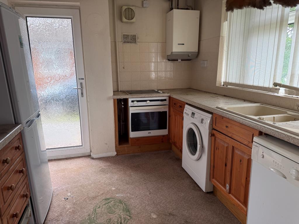 Lot: 159 - BUNGALOW WITH GARAGE AND GARDENS IN NEED OF MODERNISATION - Kitchen with window and glazed door to side access